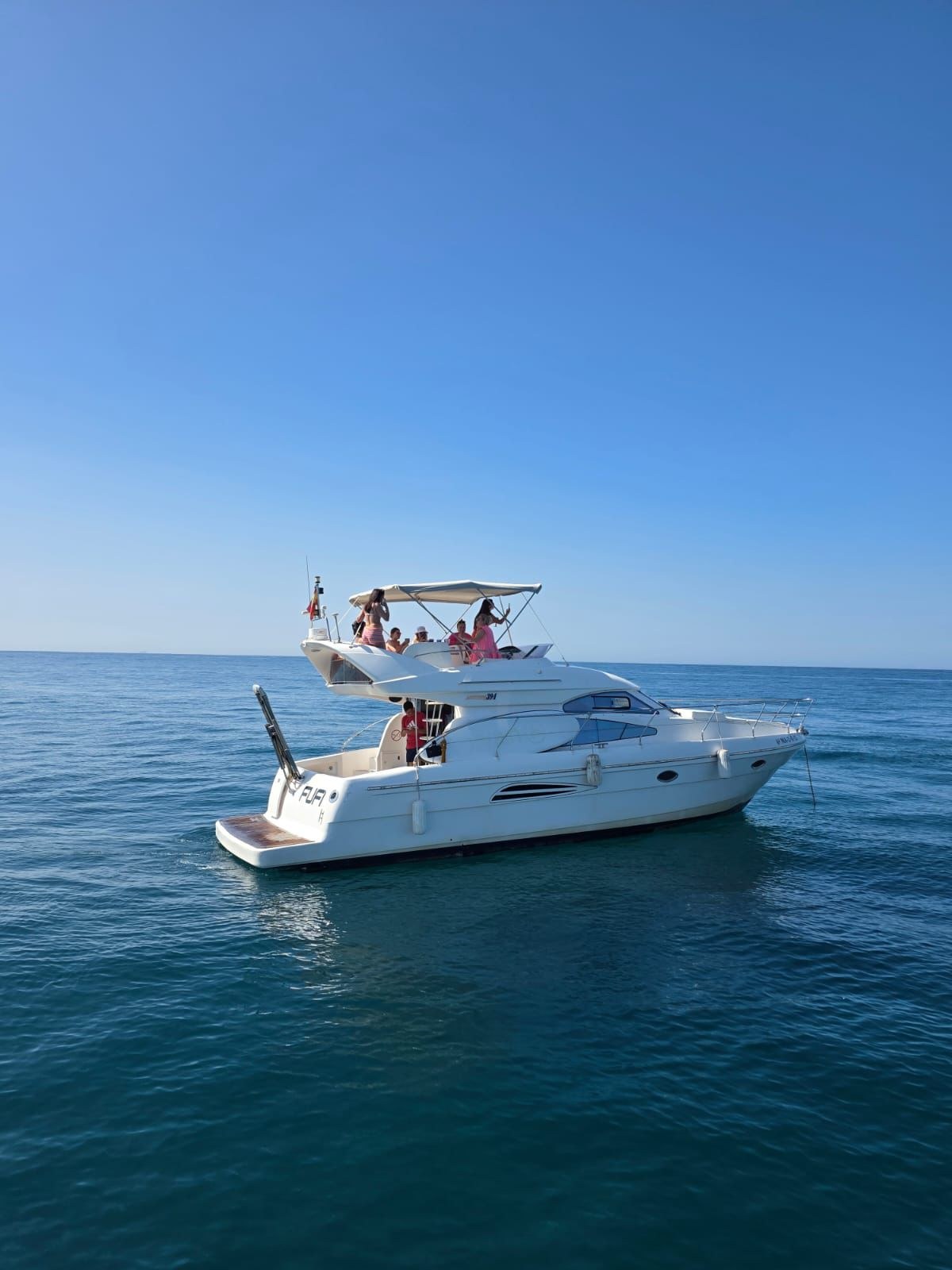 Side profile of the Astondoa 40 "Fufi" with guests on the flybridge