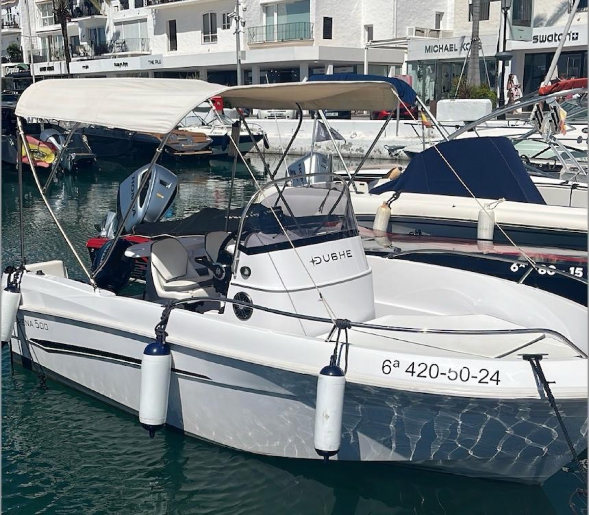 Dubhe side profile docked at Puerto Banús marina with bimini top up