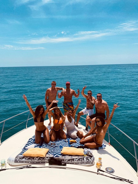 Grupo de amigos celebrando en la proa de nuestro yate de charter en Marbella