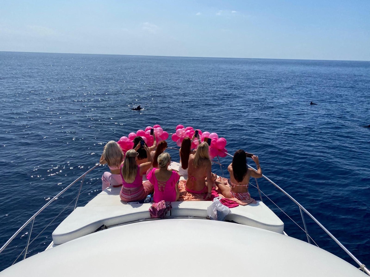 Hen party in pink on the bow watching dolphins — Marbella charter yacht