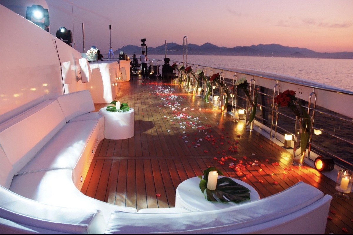 Candlelit deck dressed with rose petals for an evening wedding reception on a Marbella charter yacht